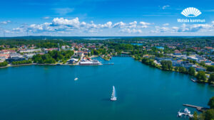 Flygfoto över vattnet i Motalaviken med fontänen Visionärens vinkelben i förgrunden och delar av stadskärnan med hamninloppet i bakgrunden.