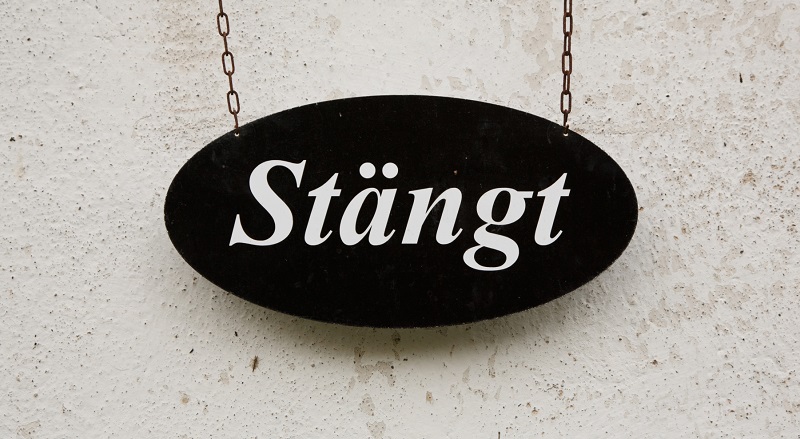 svart skylt med texten Stängt i vitt